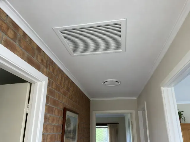 Ceiling return-air grille in a hallway with brick feature wall and doorways in Aberfoyle Park